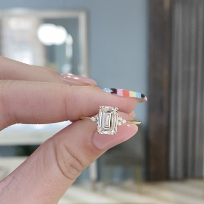 She said yes: A custom delicate engagement ring with a stunning emerald cut diamond center